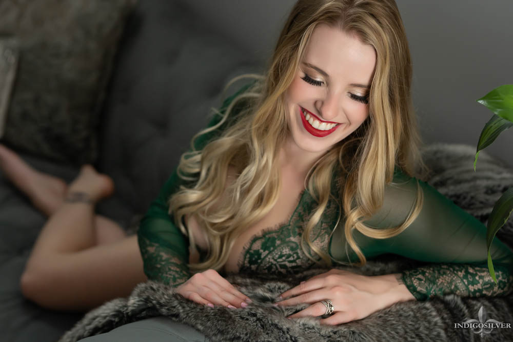 smiling boudoir portrait in green lace bodysuit